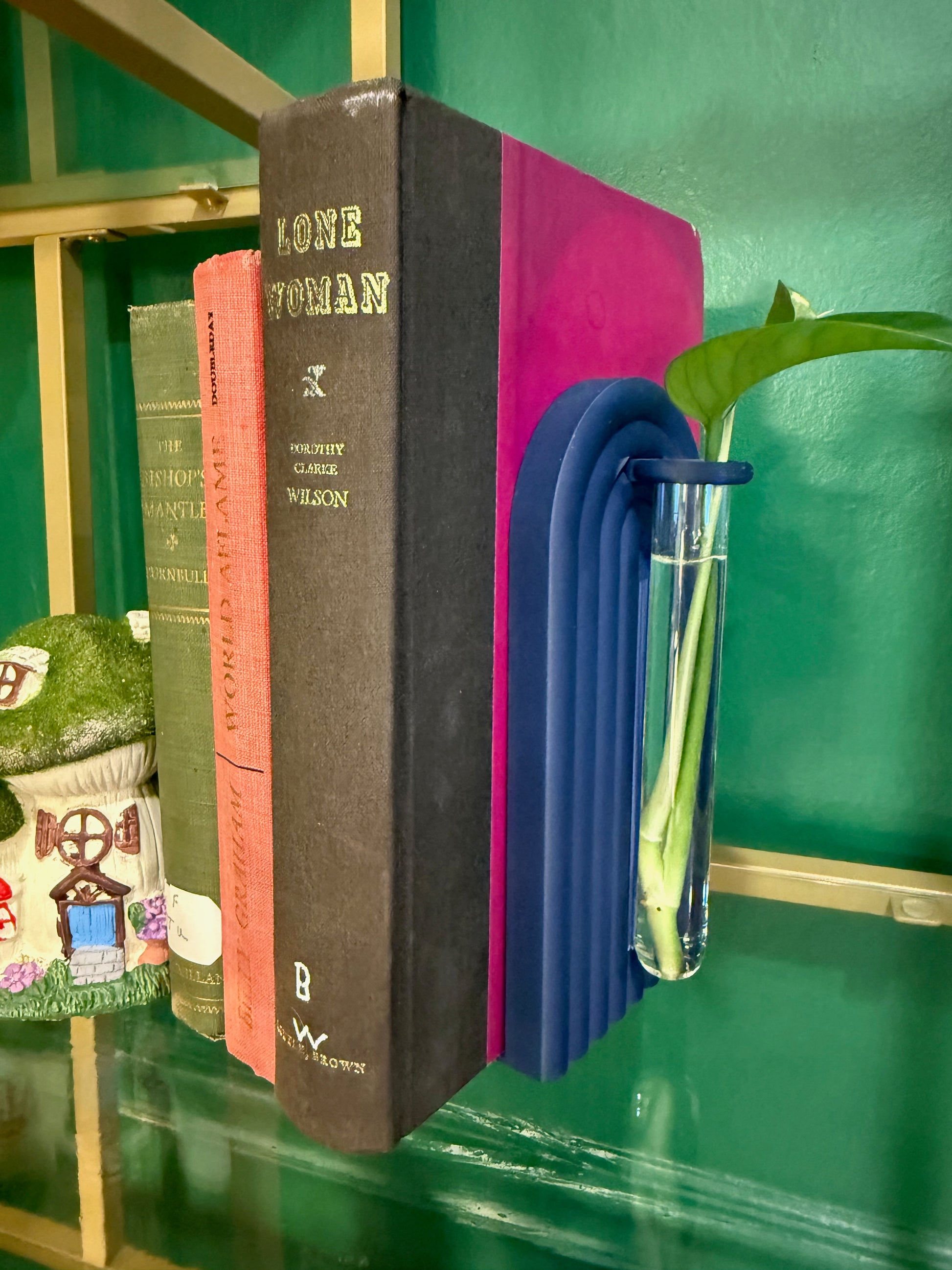 Contemporary propagation bookend featuring colorful flowers, positioned next to rich blue literature.